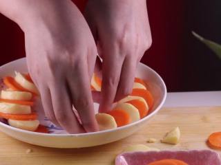 8、蒸豆腐的新吃法，口感嫩滑好吃爽口,将准备好的食材码在盘中，一块玉子豆腐一块胡萝卜片绕着盘子的一周摆放。