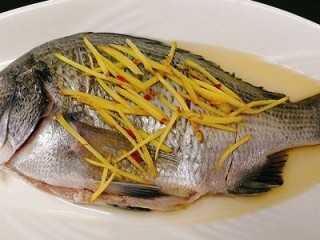 4、年年有鱼--清蒸海鲫鱼,先倒料酒至鱼的全身，姜丝铺在鱼身上，腌制5分钟左右