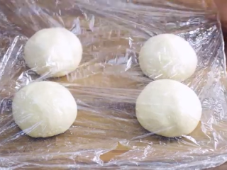 7、火腿芝士面包,面团切成四份,团成球形,盖上保鲜膜,饧一会