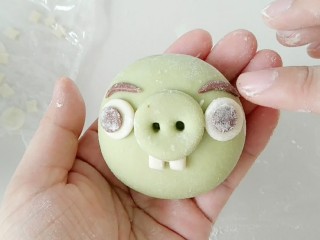 10、绿皮捣蛋猪奶黄花样餐包,在粘上眉毛，粘不住的时候，蘸些水。