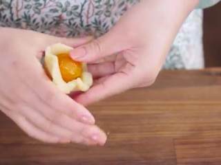 11、蛋黄莲蓉月饼,取一份莲蓉搓圆按扁，包入一颗咸蛋黄，用虎口处把莲蓉往上包住蛋黄搓圆即可