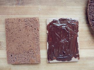 20、可可钢琴蛋糕,烤好的饼干取出晾凉，将蛋糕片照饼干的大小切好，在饼干上涂少许融化的黑巧克力，将薄、厚两片蛋糕片依次放在饼干上