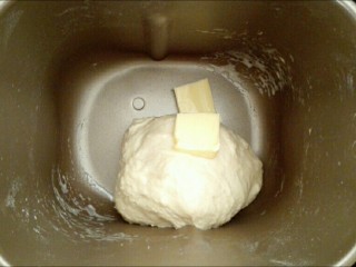 1、馅料足足的超级至尊匹萨,先将黄油以外的面团材料（加牛奶的时候注意观察面团的湿度进行调整，不要一次加完）放入面包机中，启动揉面功能，约10分钟揉成光滑面团后，加入切成小块的软化的黄油（如果用玉米油可以所有面团材料同时放入），