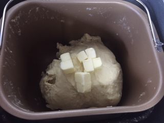 3、烫种牛奶吐司,面包机启动揉面发酵功能。（面包机的生面团键）揉成光滑的面团，出现粗膜状态加黄油和盐（就是常说的后油后盐法）。