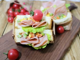 14、口袋三明治,14. 把火腿片卷一下从中间断开,放入切口里,再放些杂蔬,挤上点沙拉酱或者番茄酱都可以,口袋三明治就做好了