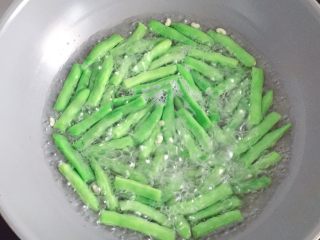 5、干煸四季豆,水开后放入四季豆焯至断生(四季豆没熟吃了会中毒,一定要焯熟)