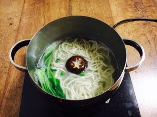 7、酱牛肉面,然后再次开火煮至沸腾，把豌豆、鲜香菇、小油菜依次放入锅里煮开。