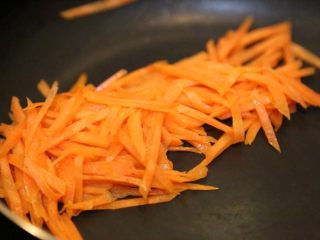 7、腊肠石锅拌饭,放入胡萝卜丝炒熟。