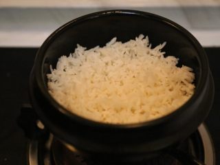 14、腊肠石锅拌饭,在石锅底部铺上米饭。