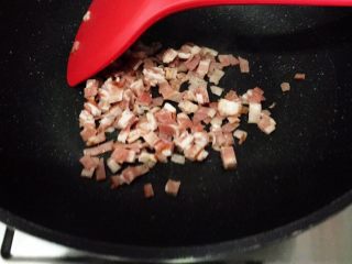 2、芝士黑麦土豆培根软欧,中火，锅里放入培根碎稍煎一下