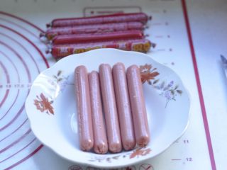 5、萌萌的小兔面包,5、把买来的香肠，用小刀将肠衣切口，撕掉肠衣备用