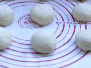 7、萌萌的小兔面包,7、取出排气后，将面团分割成90g左右的6块，  然后滚圆 盖上保鲜膜 松弛10分钟，这个必须做，否则擀不开长度