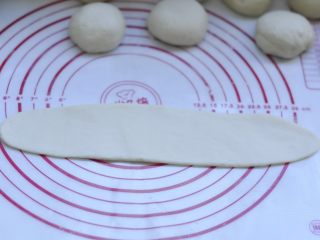 8、萌萌的小兔面包,8、取一块按扁，擀成牛舌状 长度约25cm 宽度7左右