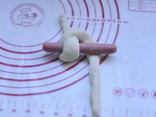 13、萌萌的小兔面包,13、香肠放n型面上，把2个头搭过香肠