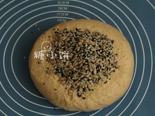 4、杂粮三角包,将发好的面团取出，加入葵花籽和黑白芝麻。这一步我没有揉搓，是用一次次折叠的方法把果料和面团混匀的。
