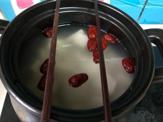 10、健康美味红薯绿豆大枣粥,取一双筷子，搭在砂锅口，如图所示。