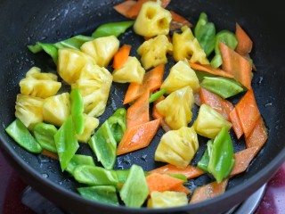 11、菠萝咕咾肉,锅中留少许底油,放入青椒、胡萝卜和菠萝炒出香味