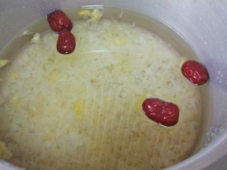 4、养颜营养早餐,取一个深一点的锅，放入剁碎的糯耳，和枣，加水沫过炖煮一小时