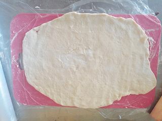 3、玫瑰苹果塔～,用擀面杖把面擀成一个薄薄的面皮。大而薄，要尽量方而不圆。长要保证不少于20cm