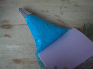 10、海洋之星——意式马卡龙,裱花袋装入圆形花嘴,杏仁糊装入裱花袋,用刮板推至花嘴处。