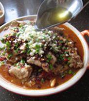 25、传统水煮牛肉,锅中再次烧热油，取适量浇在蒜末、青蒜苗和麻辣酥上，一定要听到“滋滋啦啦”的声音