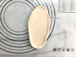 5、原味贝果,取一面团,稍加按扁后擀成长舌形,边上按出空气。