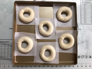 8、原味贝果,将整完形的面包圈放在油纸上再摆入烤盘。