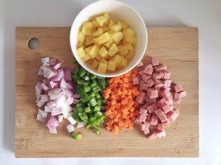 6、粗粮凤梨炒饭,取出的凤梨肉、洋葱、青椒、胡萝卜、火腿肉切成丁。