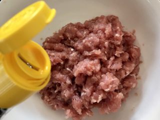 5、蘑菇馄饨,淋入少量麻油，搅匀，盖上保鲜膜入冰箱冷藏二十分钟。