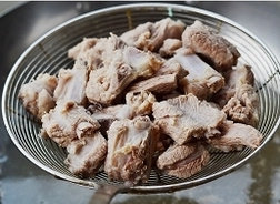 4、姜爆回锅排骨,锅中加入适量的水烧开，倒入排骨，焯水，去除浮沫。