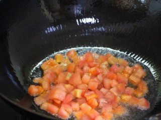 8、水煮鱼片这么烧,健康营养有颜值!全家人吃了赞不绝口!,锅里烧热油,下番茄丁进去炒出色