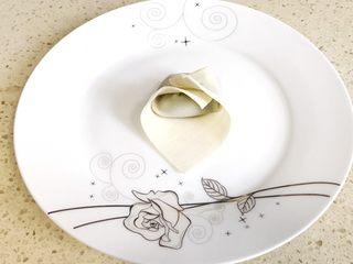 6、#咸味#漂亮的馄饨太阳花,再抓住另外一头,对叠过来,并将两头紧紧地捏合住