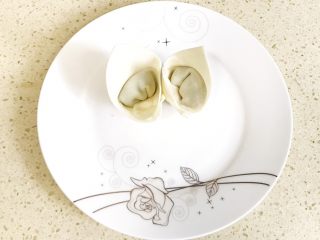 8、#咸味#漂亮的馄饨太阳花,依此方法再包一个,和第一个一样立起来,放在盘子的中心,让两个馄饨相依而立