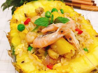 9、海鲜菠萝饭,最后加入米饭，放芝麻油，蚝油，一点点酱油和稍许盐！翻炒，最后盛起来装盘，把虾摆摆好就ok啦????