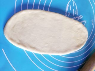 5、千层椰蓉面包卷,拿一个面团用擀面棒擀扁，包入椰蓉馅团，再搓成小面团。用擀面棒把它擀成一个舌形状。