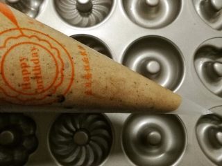 12、巧克力豆甜甜圈蛋糕,12.裱花袋剪一个口子，口子不能太小，要比巧克力豆大。