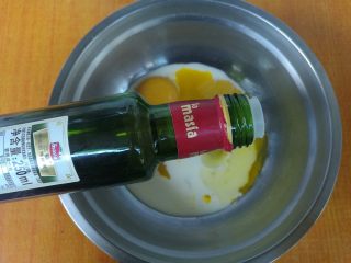 3、网红花生小贝蛋糕,蛋黄盆加入牛奶、糖10克,橄榄油。