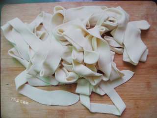 4、油泼扯面,两手捏住烩面片的两端，抻一抻，从中间的压痕处将面自然地扯断为两根。