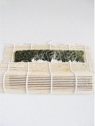 11、紫菜包饭,将竹帘卷起，先将米饭上的鸡蛋萝卜等卷起，卷起之后用双手均匀的将卷好的部分捏紧