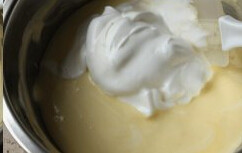 8、轻乳酪草莓,继续取三分之一蛋白混入奶酪糊中，切拌均匀