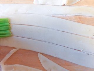 15、香死个仁儿的★葱油饼「佳儿秘方」,然后刷葱油，再涂上一层盐。再切条。