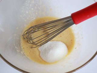 5、焦糖香蕉玛德琳花环,混合均匀后加入细砂糖搅拌均匀，注意搅拌的过程不需要打发鸡蛋，都是混合均匀即可