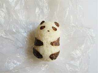 4、熊猫趣味早餐饼,将剪好的海苔贴在米饭团上，变成一只可爱的熊猫