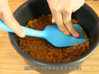 4、芒果流心慕斯,把和无盐黄油混合好的饼干碎倒入模具中，用刮刀压平压紧压实，然后放入冰箱里面冷藏，一定要压实，不压实，脱模切件的时候很容易会散掉