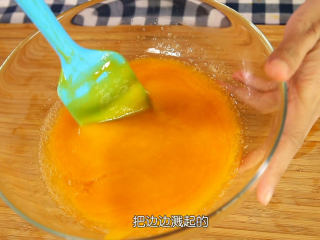 8、芒果流心慕斯,吉利丁片沥去多余的水分，放在一个干净的碗中隔水融化成液体，把融化好的吉利丁液倒入慕斯部分的芒果泥里面用刮刀快速混匀（如果期间出现结块的现象，可以整碗芒果泥隔水加热一下，让凝固的吉利丁再次融化，如果吉利丁没有跟芒果泥混匀，会造成慕斯不成形，出水）