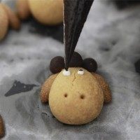 12、小羊曲奇,取出后的曲奇稍微晾凉,然后用白色糖霜和黑色巧克力画上眼睛即可。