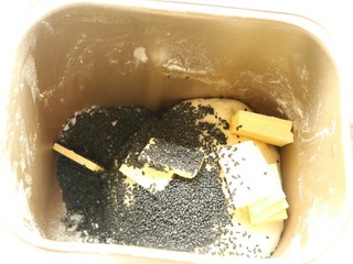 5、中种法黑芝麻吐司,第一个程序结束，加入黄油和炒香的黑芝麻，再次开启面包机，揉面15分钟。