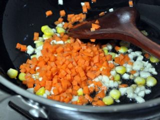 8、五谷杂粮炒饭,倒入胡萝卜丁，继续翻炒。