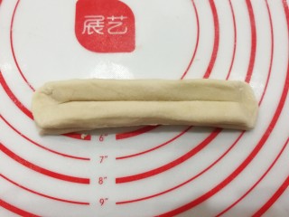12、自制健康小油条,然后两头捏紧捏扁,顺势把面块拉伸长一些;