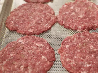 1、芝士酱牛肉汉堡,肉摊成约厚5毫米的饼状，烤盘刷上一层油后放上牛肉饼，撒上适量食盐。放入烤箱约3分钟。